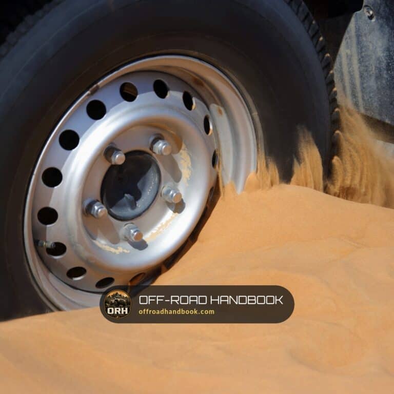 Steel wheel of a 4x4 spinning and digging into soft sand — Off-Road Handbook