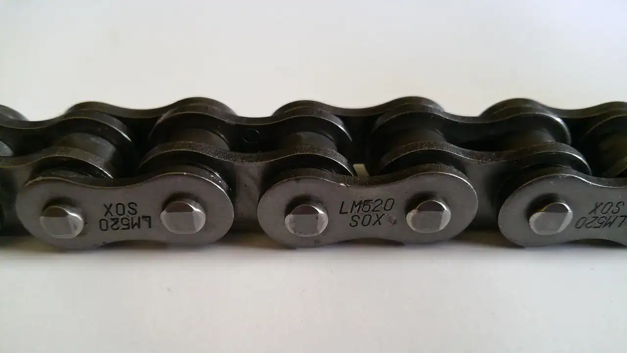 Close-up of a 520-size motorcycle drive chain on a white background