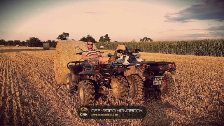 Two riders on utility ATVs in a harvested farm field — Off-Road Handbook