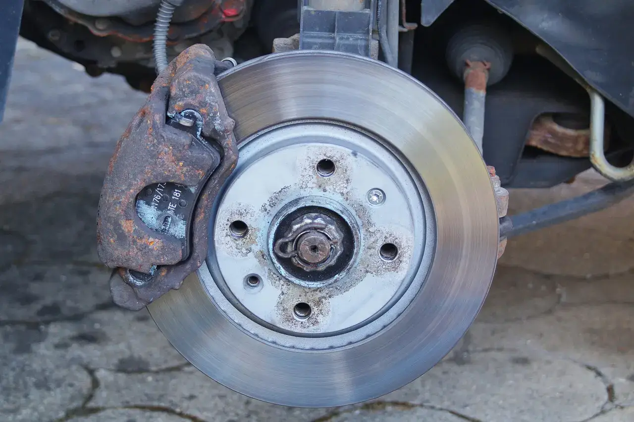 Vented brake disc and caliper with the pad visible during a brake inspection
