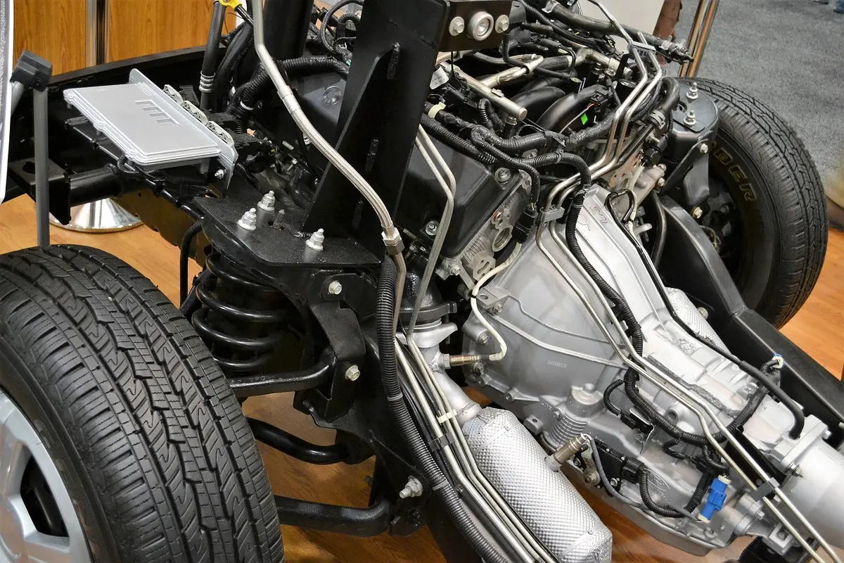 Engine and transmission mounted in a bare vehicle chassis with a tire at the left