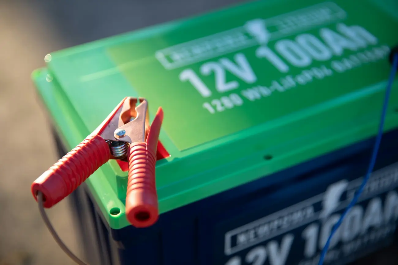 12-volt battery with a red clamp attached to the terminal