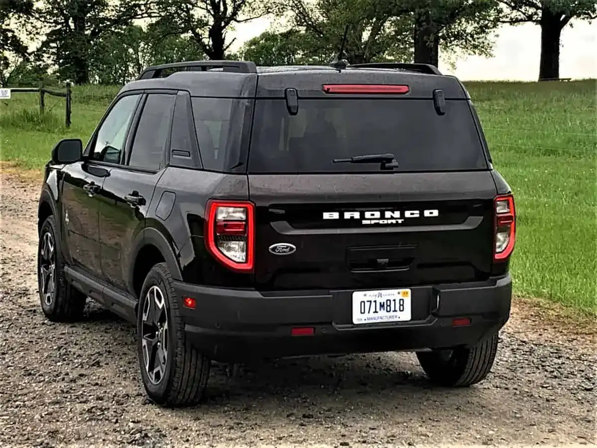 Gray Ford Bronco Sport viewed from the rear quarter on a gravel pullout above dry rolling hills