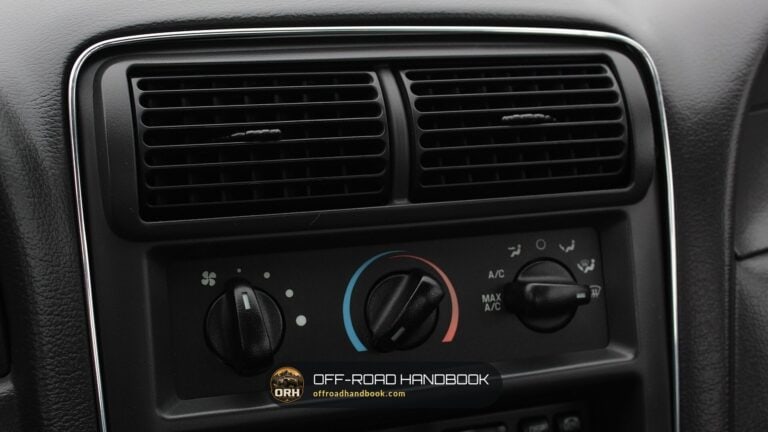 Car climate control knobs and air vents on a dark dashboard — Off-Road Handbook