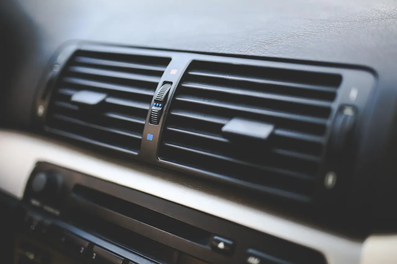 Wide air vents on a car dashboard above the climate controls (not a Jeep)