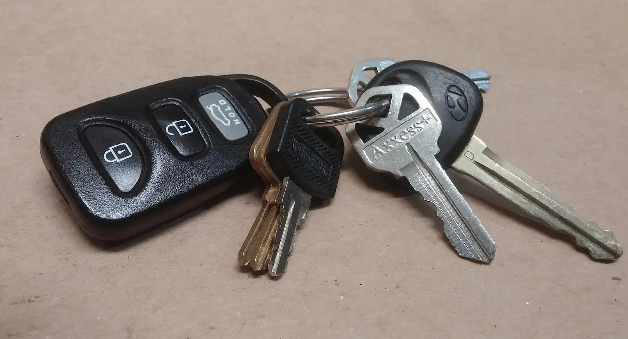 A ring of car keys with a remote key fob, one key with a plastic transponder head