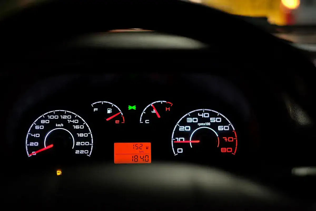 Car instrument cluster with speedometer, tachometer and warning lights glowing in the dark