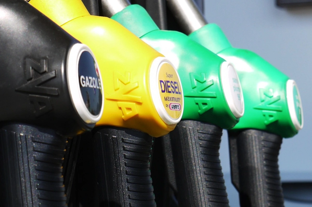 Row of fuel pump nozzles at a station with yellow and green handles, one labeled diesel