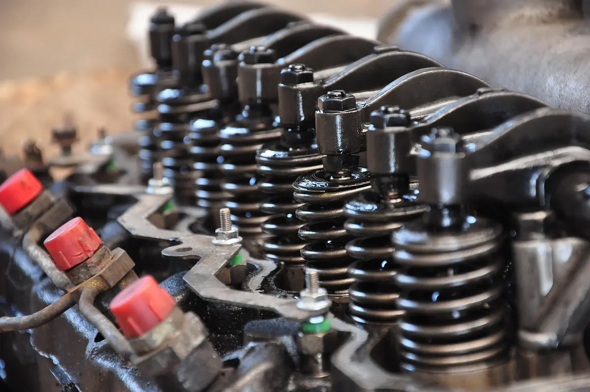 Close-up of an engine cylinder head showing valve springs, retainers and rocker arms
