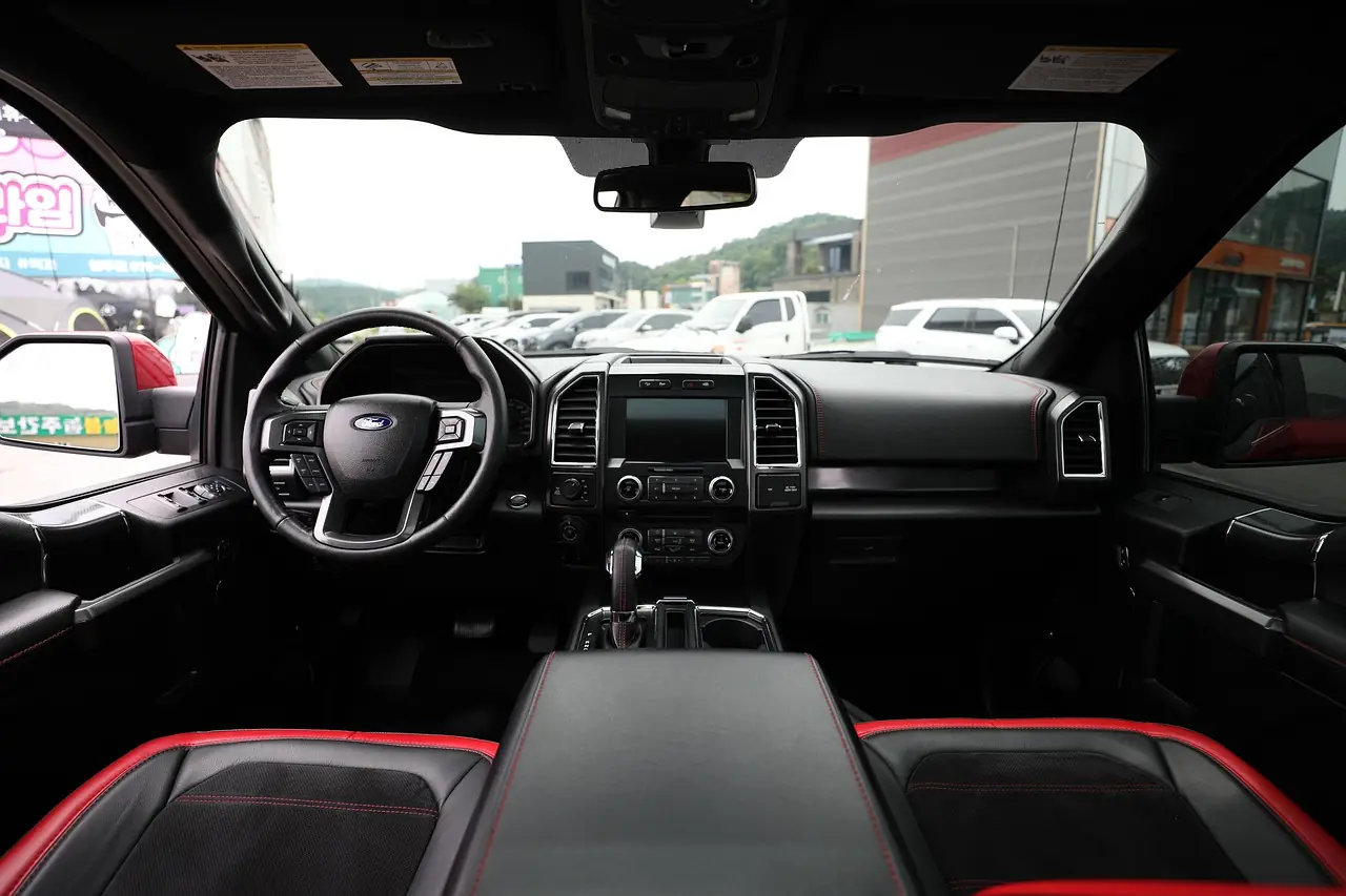 Interior of a Ford F-150 crew cab showing dashboard, touchscreen, steering wheel and leather front seats