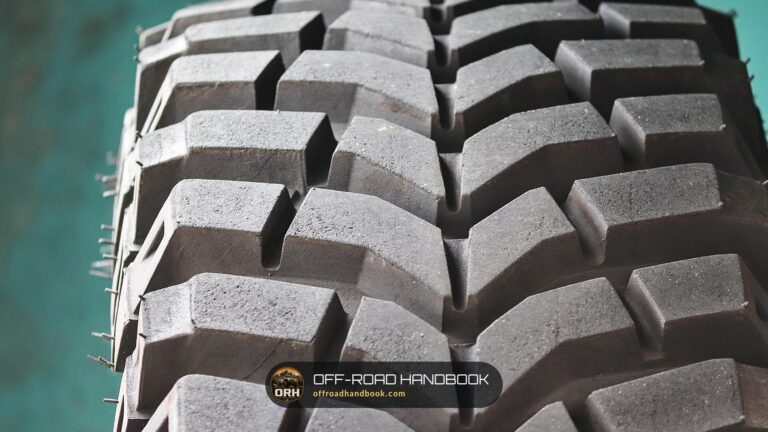 Close-up of an aggressive off-road mud tire tread with large blocks and deep grooves