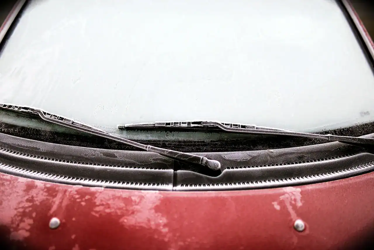 Frost-covered car windshield and wiper blades on a cold morning (not a Jeep)