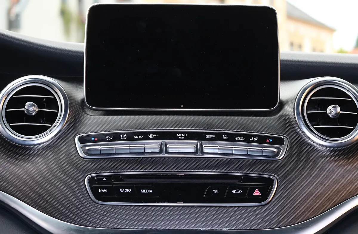 Black, switched-off infotainment screen above the air vents in a car dashboard; the car is not a Jeep