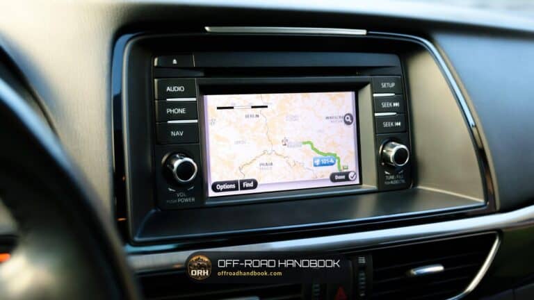Navigation screen in a car dashboard showing a route map with a green route line