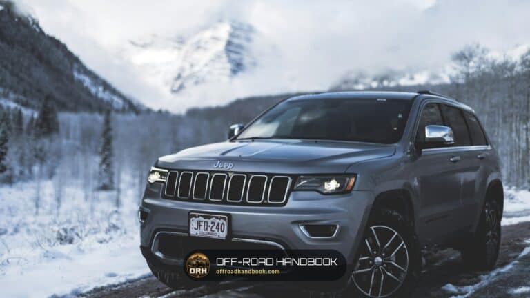 Gray Jeep Grand Cherokee parked on a snowy mountain road