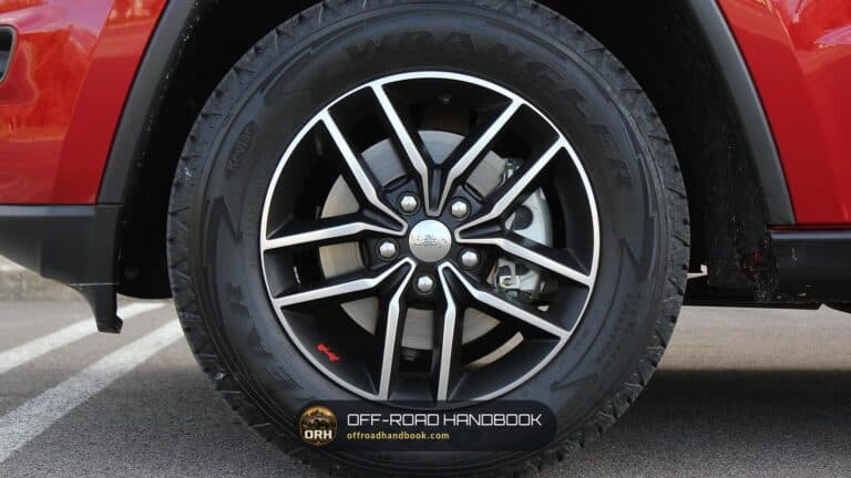 Close view of a Jeep Grand Cherokee five-lug alloy wheel with a Goodyear Wrangler tire