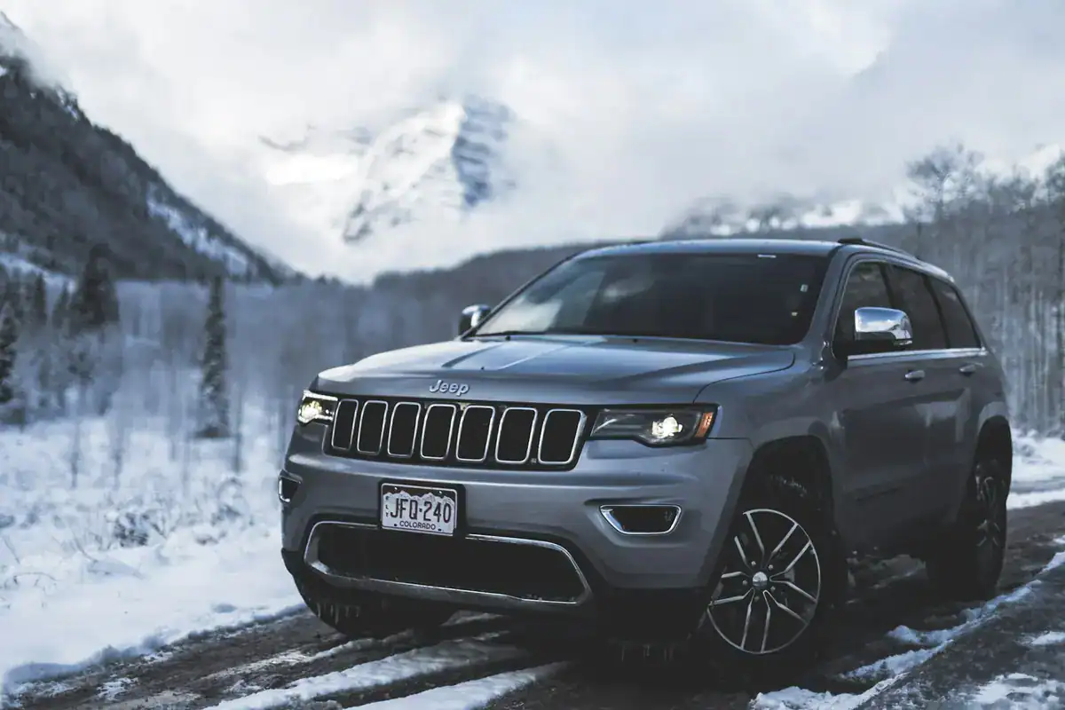 Gray Jeep SUV on a snowy mountain road