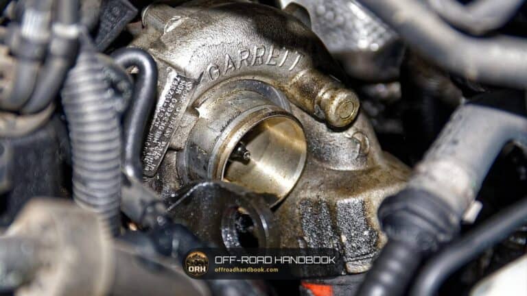 Close-up of an oil-stained Garrett turbocharger mounted on a diesel engine, the kind of part checked in turbo and boost diagnosis