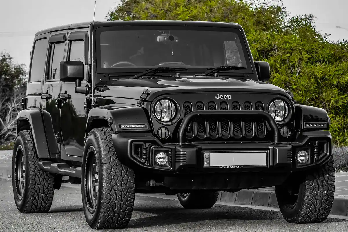 Black Jeep Wrangler on all-terrain tires, shown to illustrate how tread and sidewall sit in the wheel opening