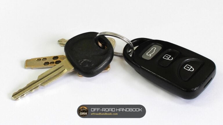 A car key with a transponder head on a ring next to a remote key fob