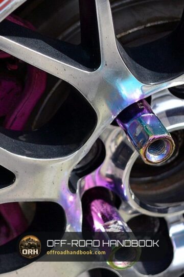 Close-up of aftermarket lug nuts threaded onto the studs of an alloy wheel