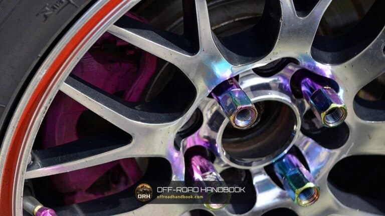 Close-up of aftermarket lug nuts threaded onto the studs of an alloy wheel