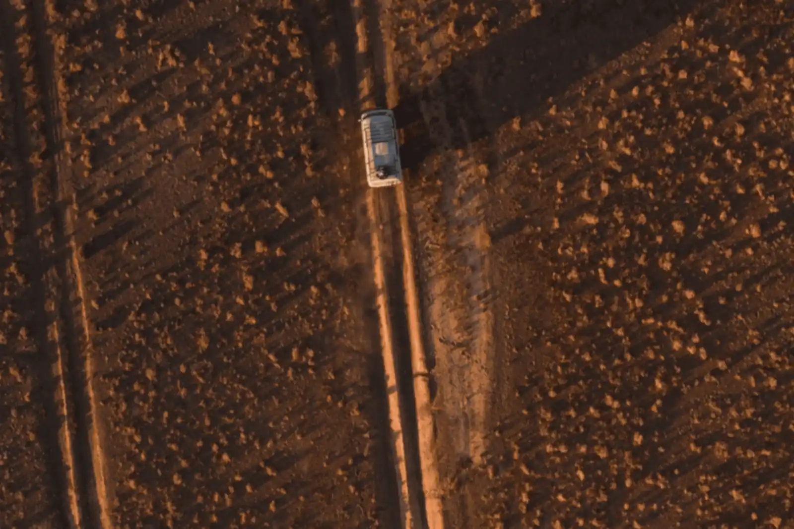 Aerial view of a 4x4 driving a dirt road through rocky ground