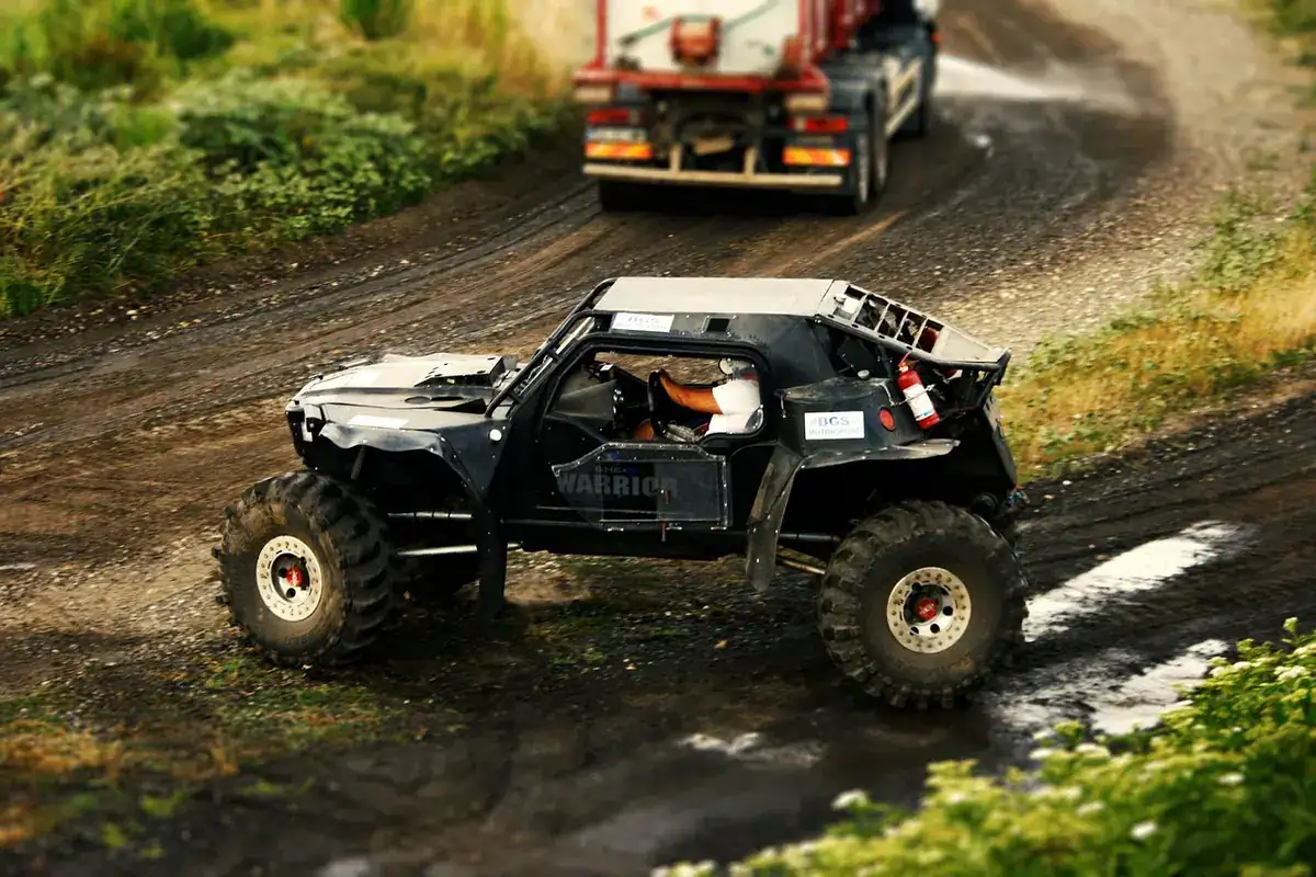Off-road buggy driving through mud on a wet dirt trail, a stand-in photo that is not a Massimo