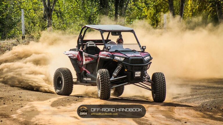 Polaris RZR XP 1000 side-by-side kicking up a cloud of dust on a dirt trail