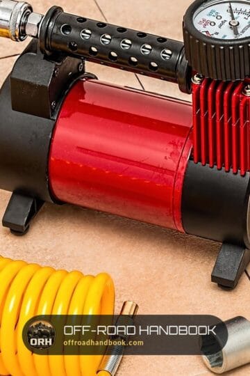 Portable tire air compressor with a pressure gauge and coiled yellow hose — Off-Road Handbook