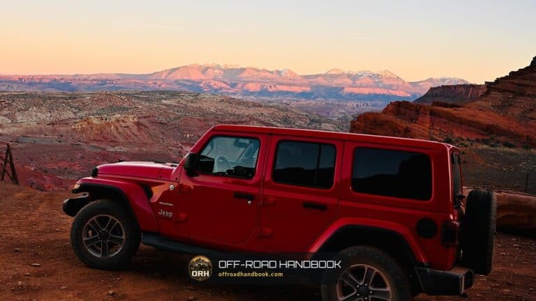 Red Jeep Wrangler parked on a red rock overlook at sunset — Off-Road Handbook