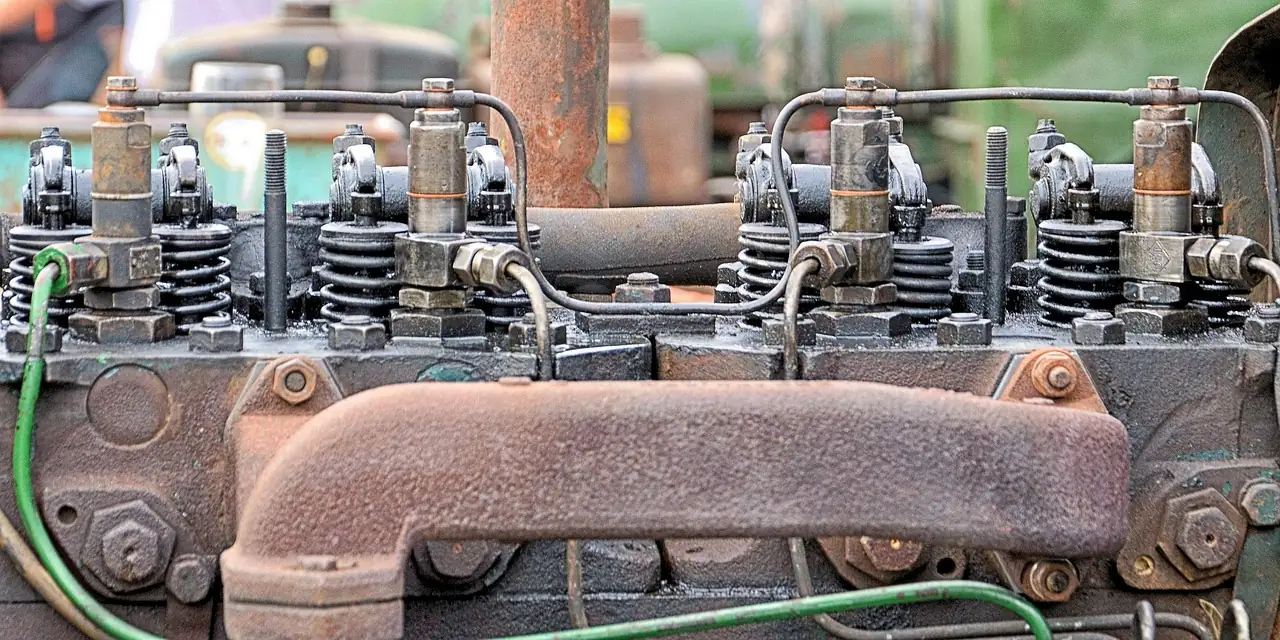 Close view of an old multi-cylinder diesel engine showing injectors, injection lines and valve springs