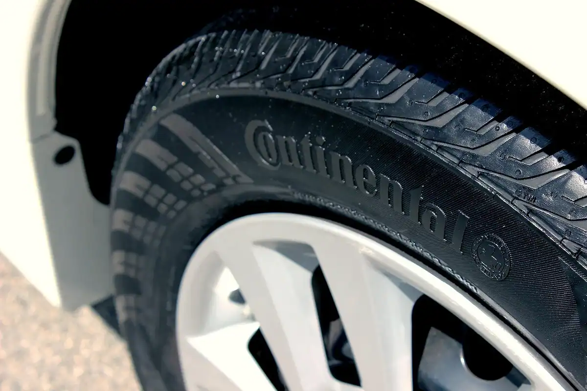 Close-up of a car tire sidewall with raised brand lettering above an alloy wheel