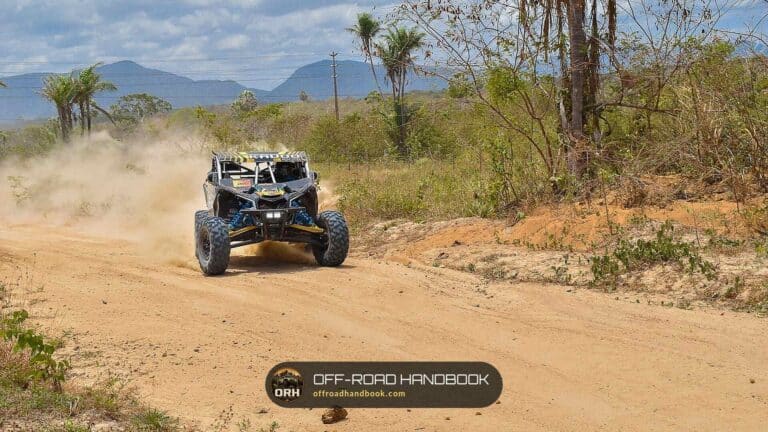 Sport side-by-side UTV kicking up dust on a dirt road — Off-Road Handbook
