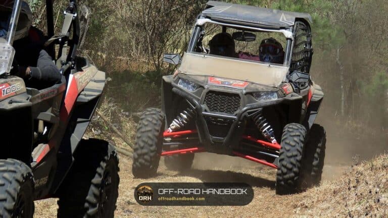 Sport side-by-side UTVs on a dusty wooded trail — Off-Road Handbook