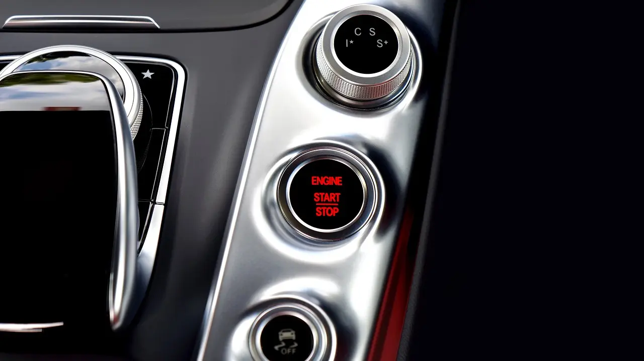 Illuminated ENGINE START STOP push button on a car center console