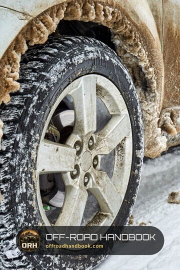 Close-up of an SUV alloy wheel and aggressive tire caked in mud and snow — Off-Road Handbook