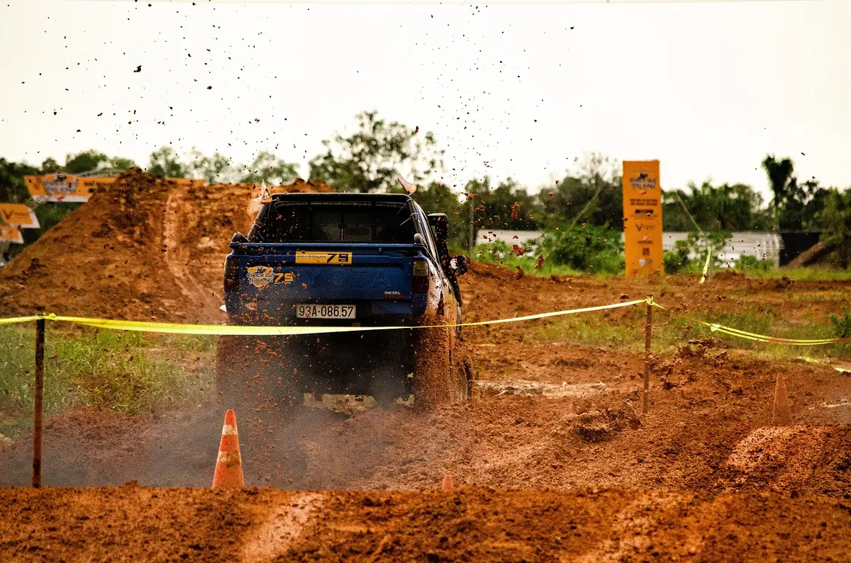 Pickup truck throwing red mud at an off-road event