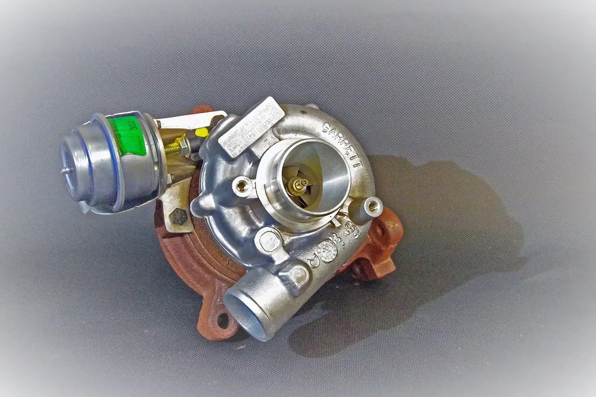 Automotive turbocharger with a round wastegate actuator canister mounted on the turbine housing