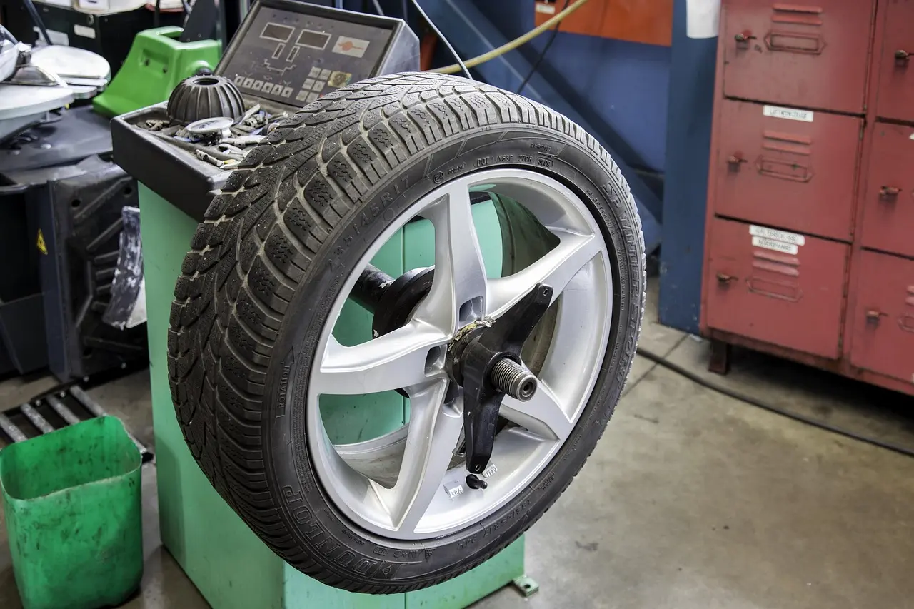 Car wheel and tire mounted on a tire balancing machine in a workshop