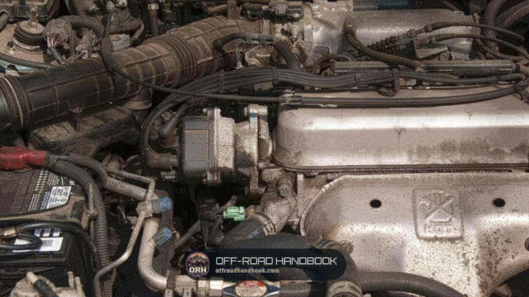 Dirty engine bay close-up showing hoses, an engine cover and an air-conditioning line, a generic engine and not a Jeep Wrangler